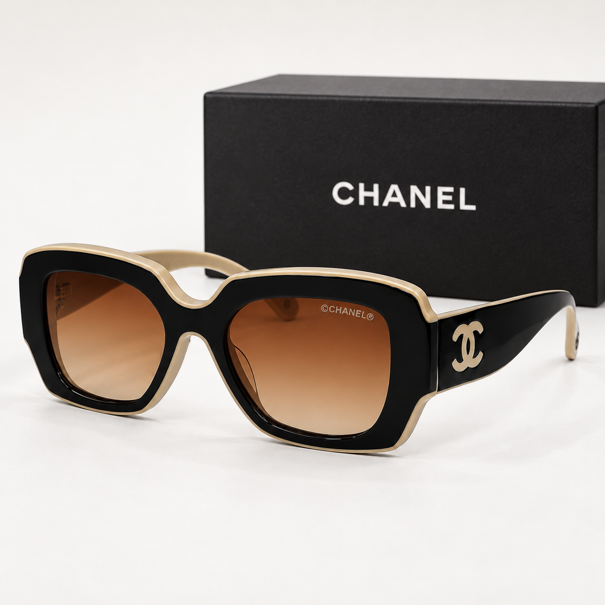 CC Contrast-Frame Oversized Sunglasses — front-left view with brand box
